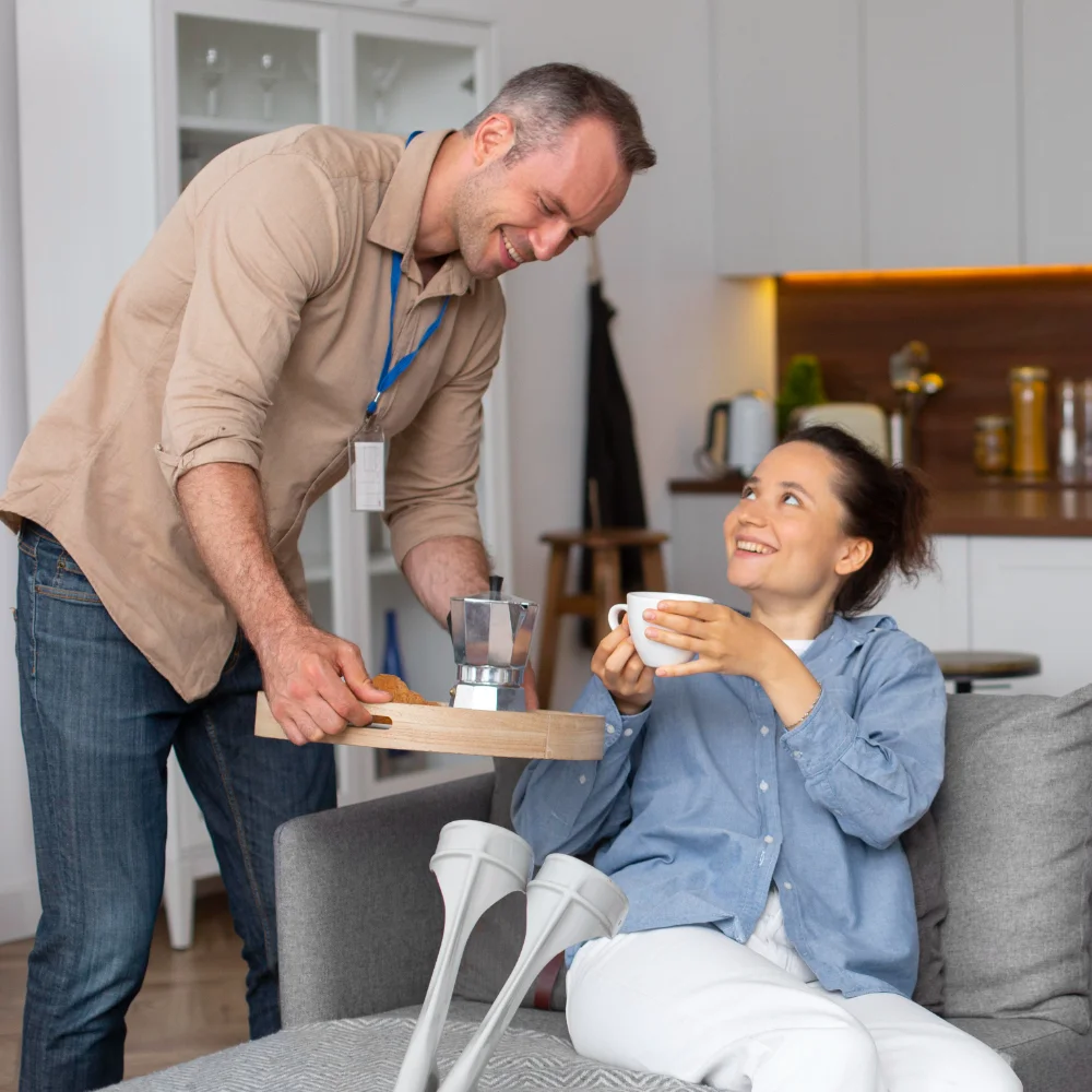 Support worker bringing a cup of tea to a woman relaxing at home