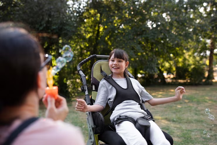 Young person in a wheelchair smiling outdoors with a companion